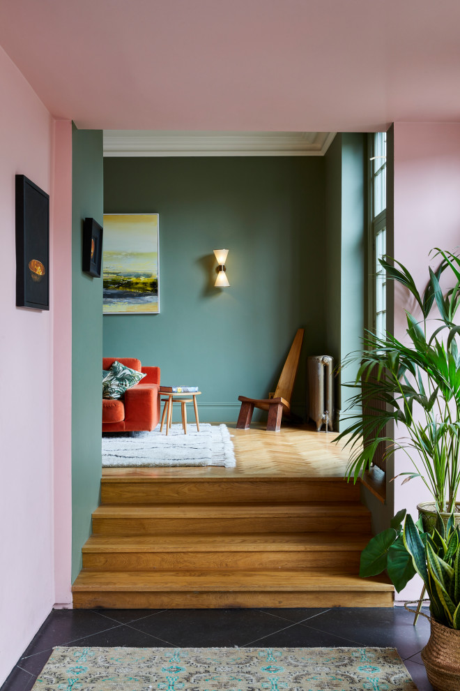 Huge eclectic medium tone wood floor living room photo in London with blue walls