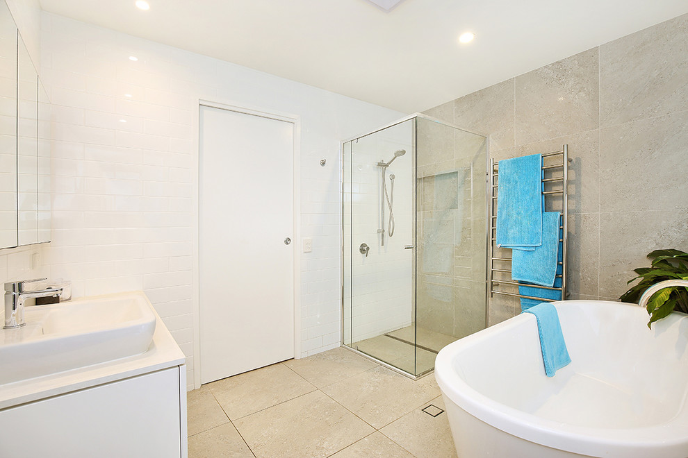 Design ideas for a large contemporary bathroom in Sunshine Coast with shaker cabinets, white cabinets, a freestanding tub, a one-piece toilet, gray tile, porcelain tile, white walls, porcelain floors, a vessel sink and engineered quartz benchtops.