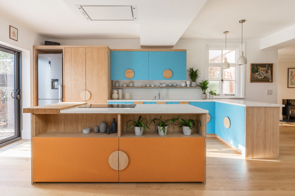 Design ideas for a large modern l-shaped eat-in kitchen in Sussex with a single-bowl sink, flat-panel cabinets, orange cabinets, quartzite benchtops, white splashback, stone slab splashback, stainless steel appliances, medium hardwood floors, with island and white benchtop.