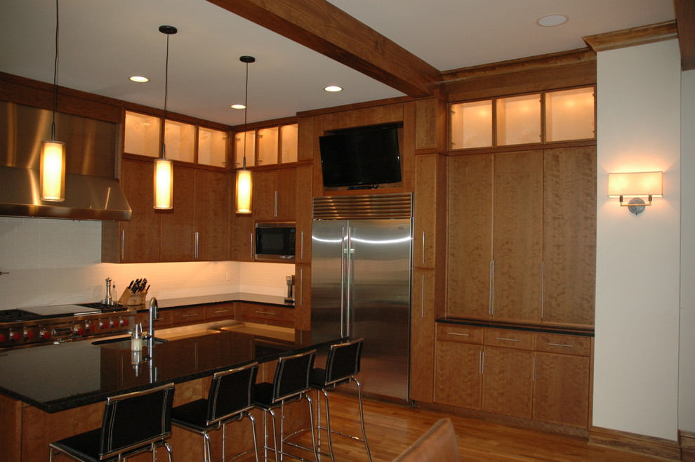 Eat-in kitchen - contemporary u-shaped eat-in kitchen idea with an undermount sink, flat-panel cabinets, light wood cabinets, granite countertops, white backsplash, ceramic backsplash and stainless steel appliances