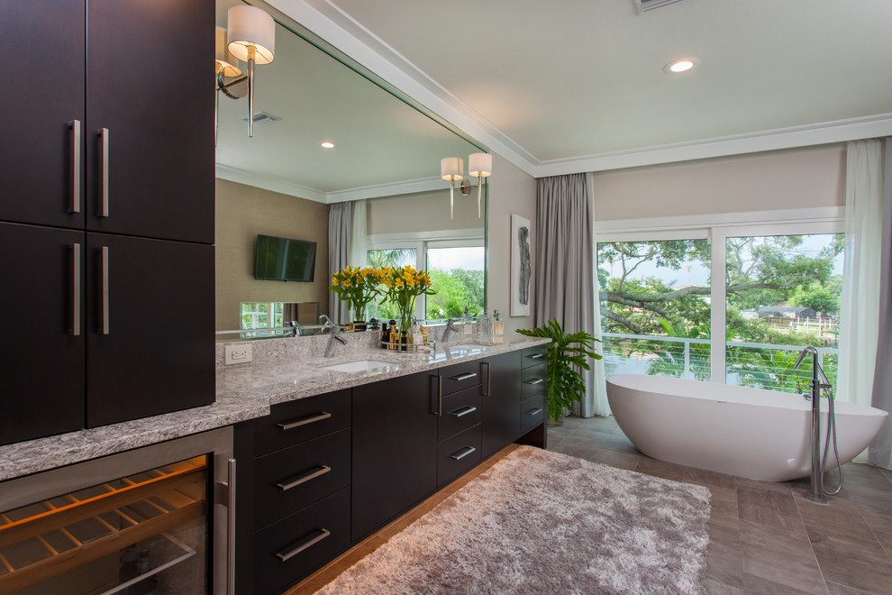 Design ideas for a large modern master bathroom in Tampa with flat-panel cabinets, brown cabinets, a freestanding tub, a double shower, a one-piece toilet, gray tile, porcelain tile, grey walls, porcelain floors, an undermount sink, engineered quartz benchtops, grey floor, an open shower and beige benchtops.
