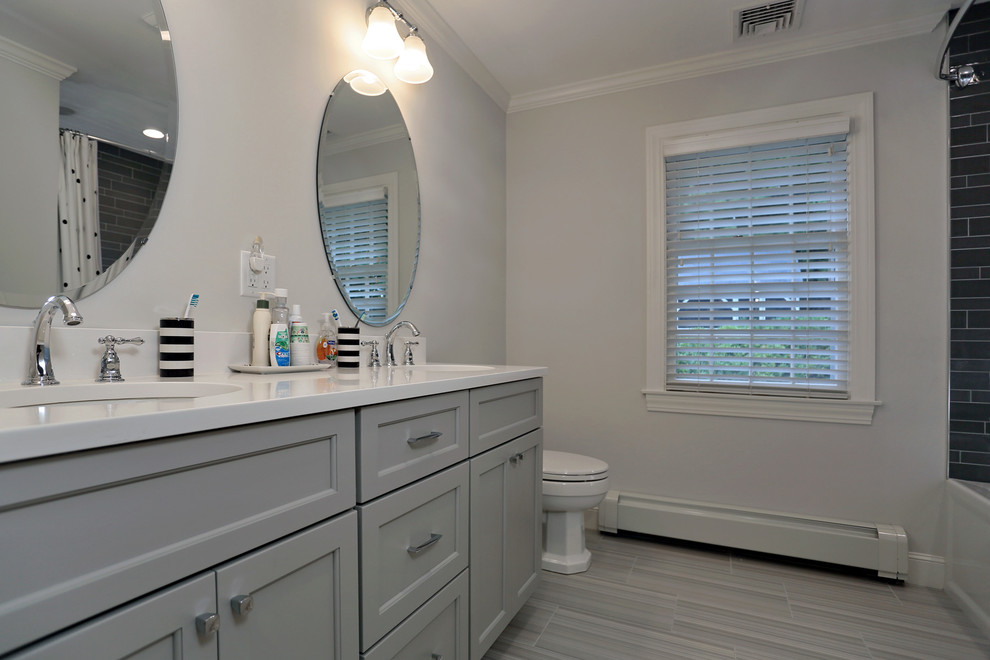 Alcove bathtub - transitional kids' gray tile and porcelain tile porcelain tile alcove bathtub idea in Boston with flat-panel cabinets, gray cabinets, a one-piece toilet, gray walls, an undermount sink and quartz countertops