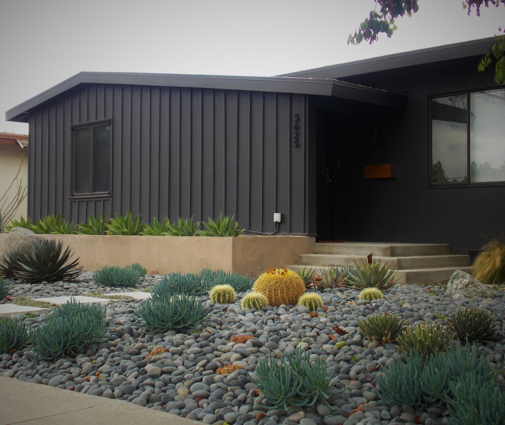 Midcentury front yard partial sun xeriscape in Los Angeles with a garden path and concrete pavers for spring.