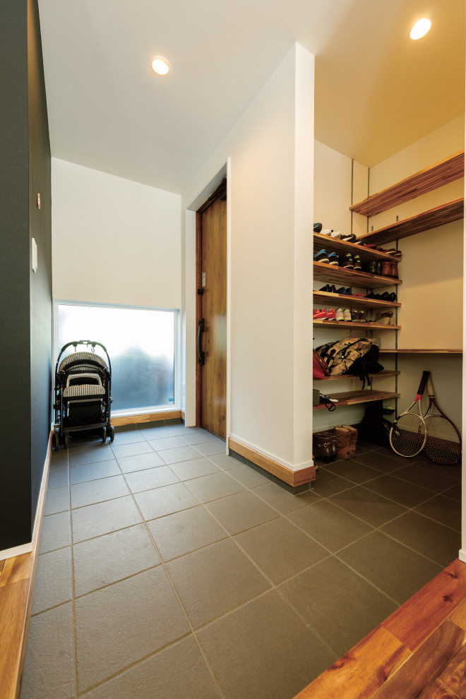 Photo of a small modern mudroom in Tokyo Suburbs with white walls, porcelain floors, a single front door, a light wood front door, grey floor, wallpaper and wallpaper.