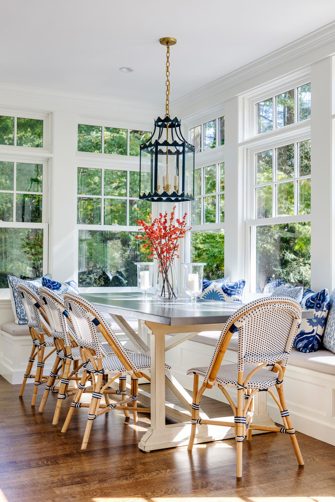 Design ideas for a beach style dining room in Boston with white walls, medium hardwood floors and brown floor.