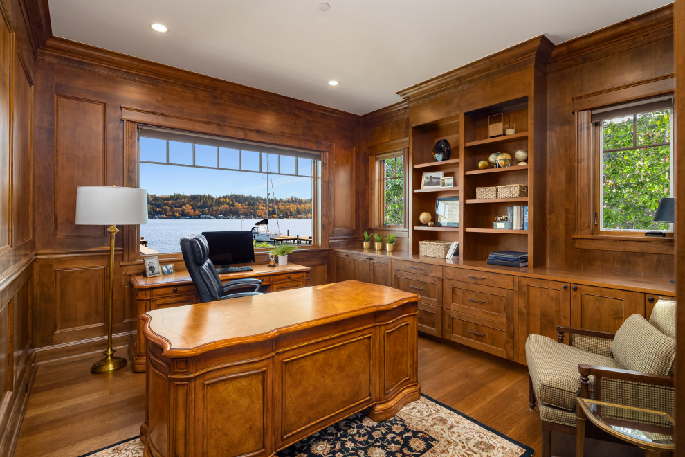 This is an example of a mid-sized transitional study room in Seattle with medium hardwood floors, no fireplace, a freestanding desk, brown walls, brown floor and panelled walls.
