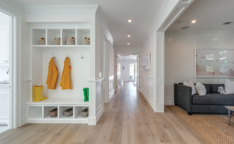 Photo of a large beach style entry hall in Los Angeles with white walls and light hardwood floors.