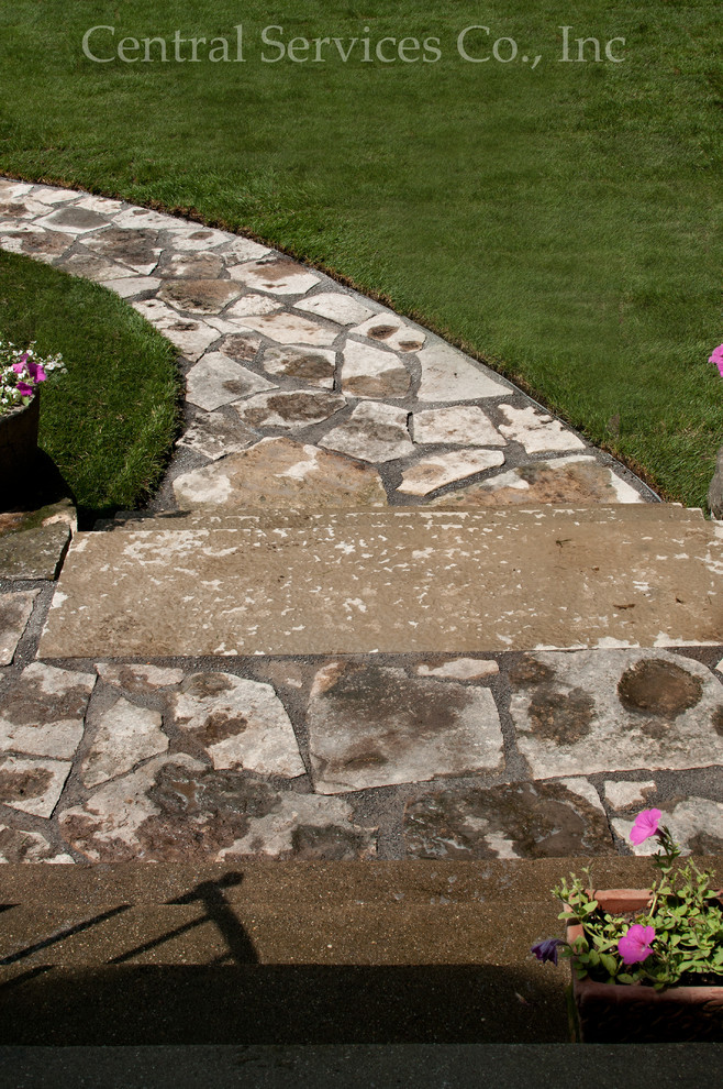 Photo of a mid-sized traditional front yard shaded garden in Milwaukee with a garden path and natural stone pavers.