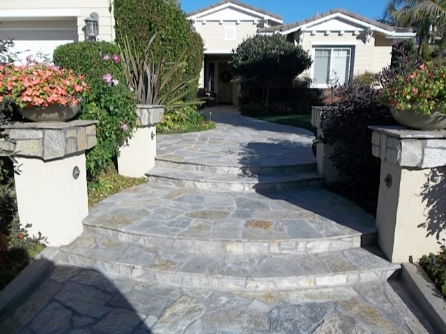 Design ideas for a mid-sized contemporary front yard full sun driveway for spring in San Diego with natural stone pavers and a garden path.