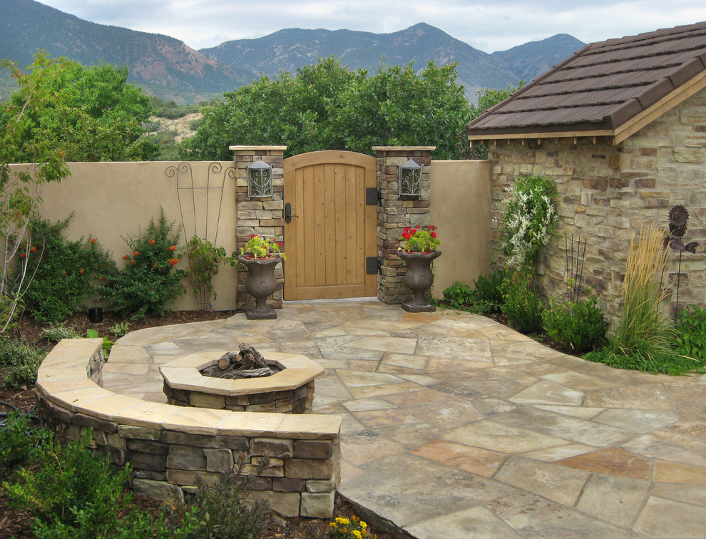 Design ideas for a mid-sized traditional courtyard full sun formal garden for winter in Denver with a fire feature and natural stone pavers.