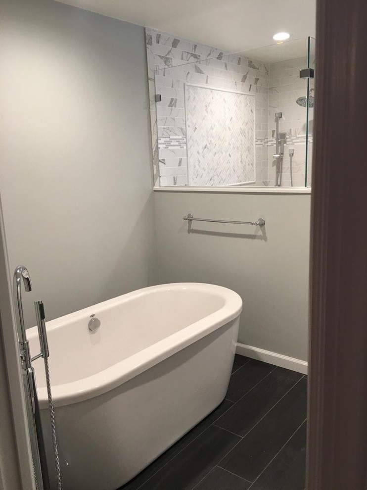 Photo of a large transitional master bathroom in New York with raised-panel cabinets, grey cabinets, a freestanding tub, an open shower, a two-piece toilet, white tile, porcelain tile, grey walls, porcelain floors, an undermount sink and engineered quartz benchtops.