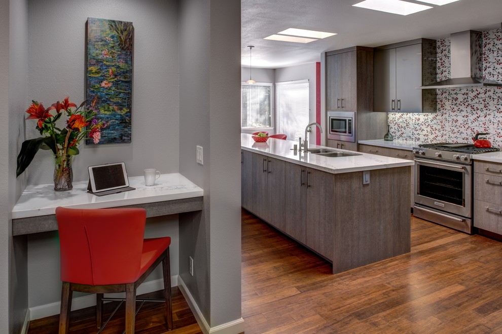 Photo of a mid-sized contemporary l-shaped eat-in kitchen in San Francisco with an undermount sink, flat-panel cabinets, grey cabinets, quartz benchtops, red splashback, porcelain splashback, stainless steel appliances, medium hardwood floors and with island.