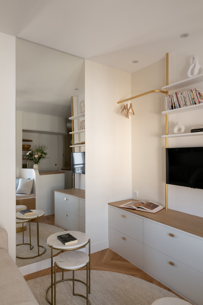 Foto di un piccolo soggiorno moderno aperto con pareti bianche, parquet chiaro, TV a parete e pavimento marrone