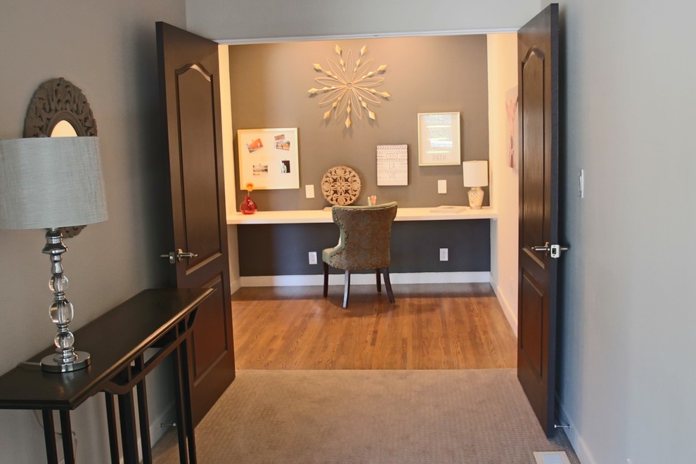 This is an example of a small contemporary study room in Albuquerque with grey walls, medium hardwood floors and a built-in desk.