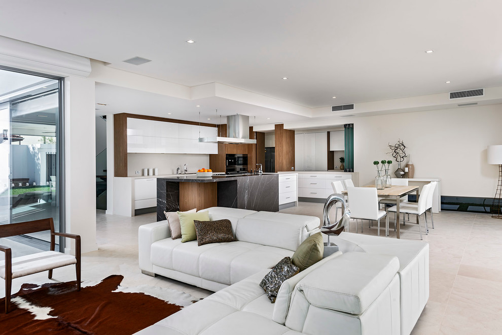 Large modern eat-in kitchen in Perth with marble benchtops, white splashback, porcelain splashback, black appliances, limestone floors and with island.