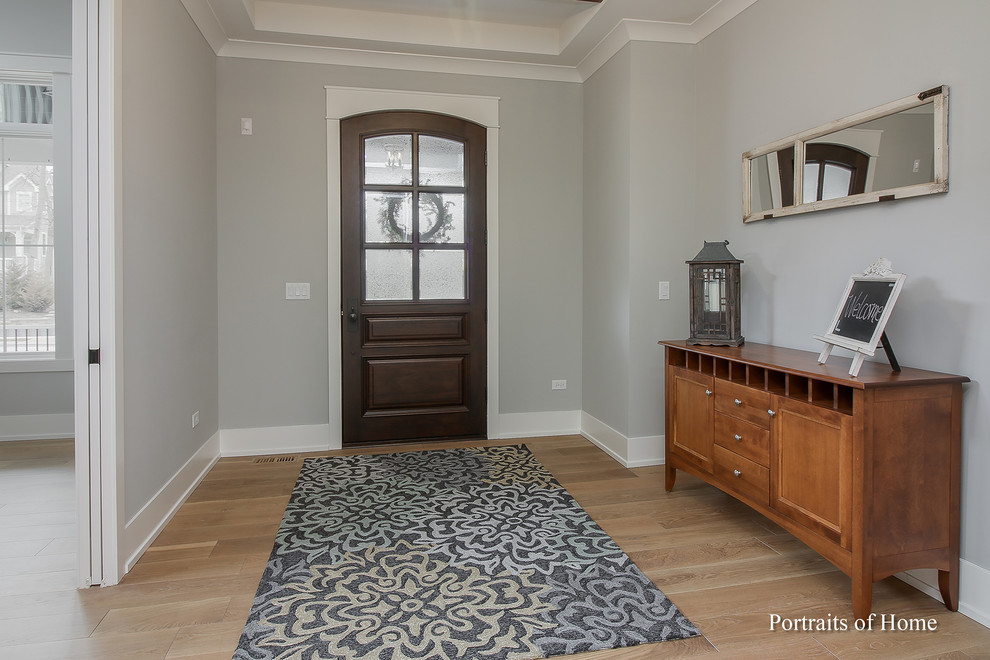 Inspiration for a large arts and crafts foyer in Chicago with grey walls, medium hardwood floors, a single front door, a dark wood front door and brown floor.