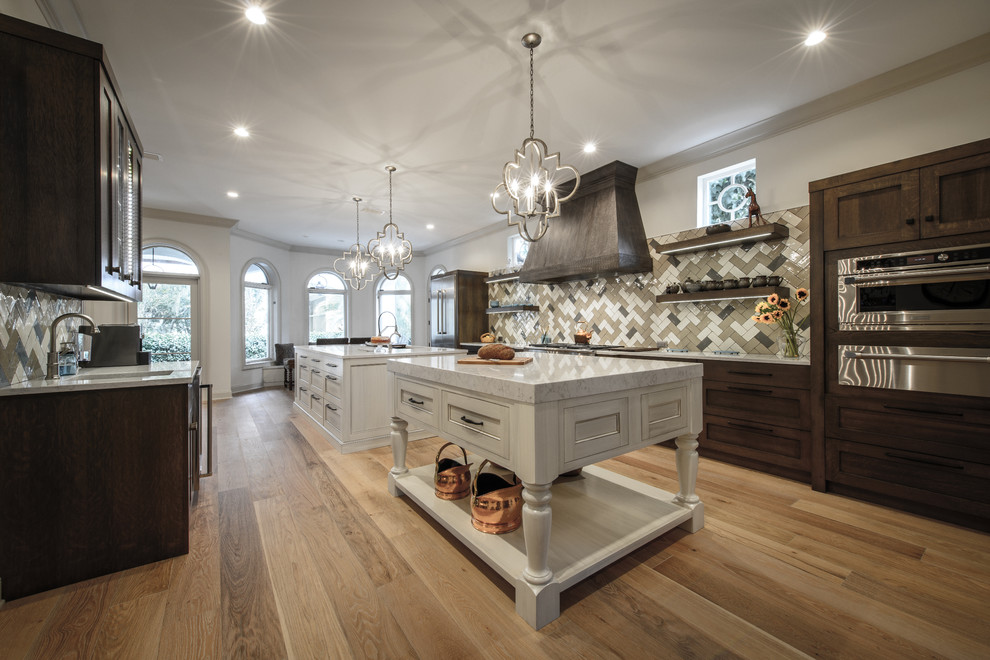 Kitchen - large transitional galley light wood floor kitchen idea in Jacksonville with a double-bowl sink, shaker cabinets, white cabinets, quartz countertops, brown backsplash, ceramic backsplash, stainless steel appliances and two islands