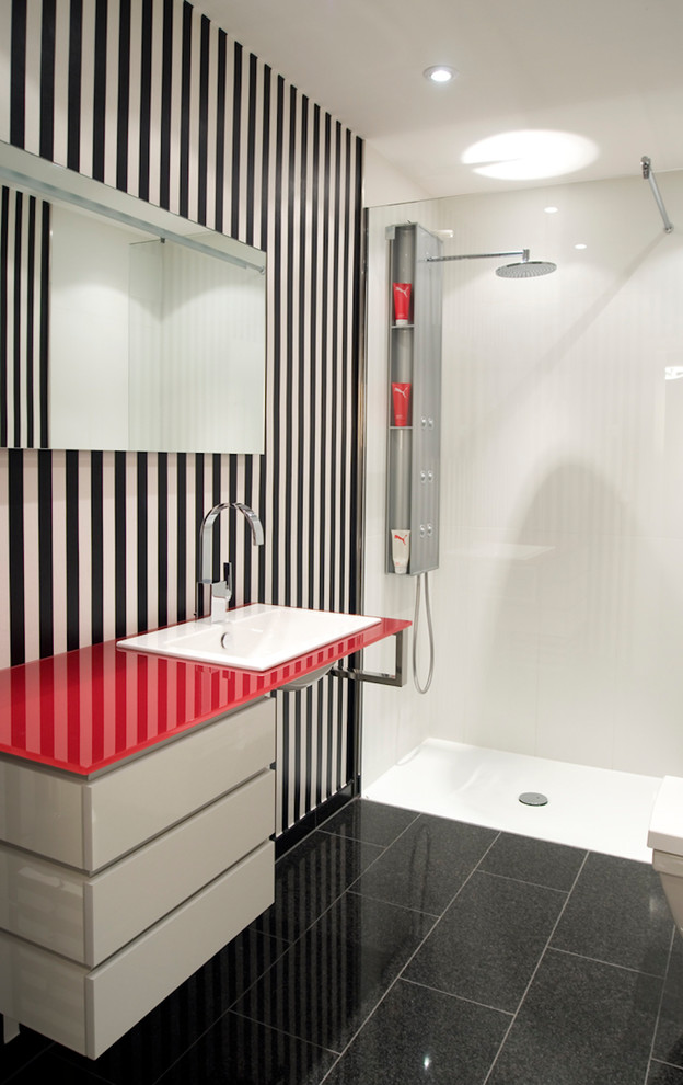 Inspiration for a small contemporary bathroom in Dusseldorf with flat-panel cabinets, white cabinets, a curbless shower, white walls, porcelain floors, a drop-in sink, glass benchtops, black floor and an open shower.