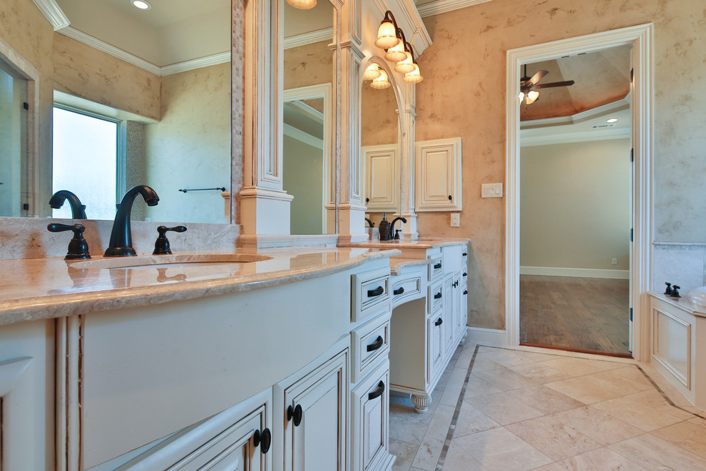 Photo of a large traditional master bathroom in Dallas with raised-panel cabinets, white cabinets, a drop-in tub, beige tile, mosaic tile, beige walls, travertine floors, an undermount sink, granite benchtops, an alcove shower and beige floor.
