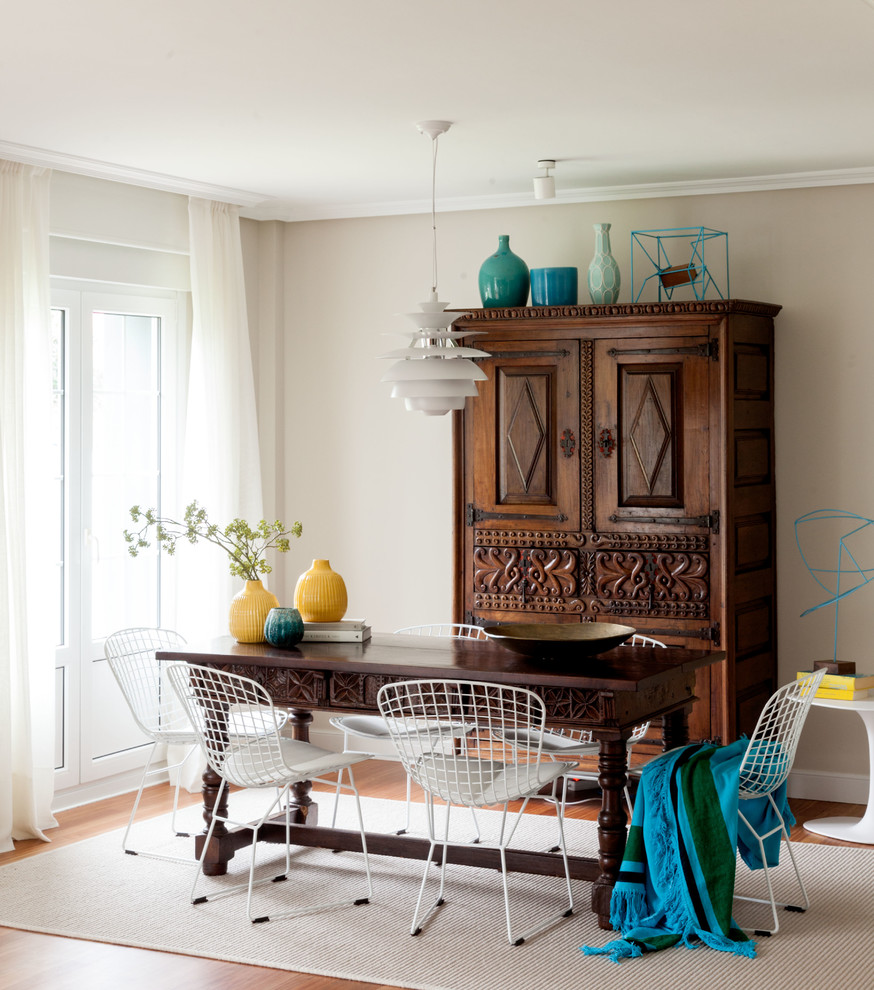 Photo of a beach style dining room in Bilbao with beige walls, medium hardwood floors and brown floor.
