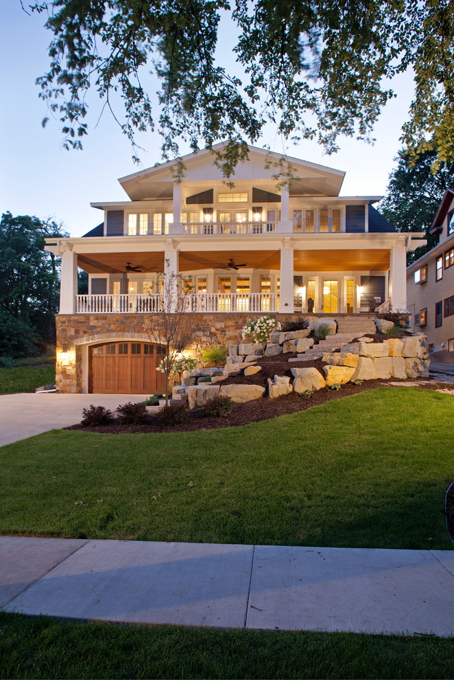 This is an example of a large traditional two-storey blue exterior in Minneapolis with stone veneer and a gable roof.