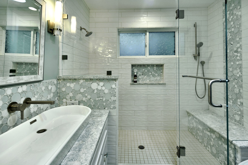 This is an example of a mid-sized contemporary kids bathroom in San Francisco with recessed-panel cabinets, white cabinets, an alcove shower, a one-piece toilet, white tile, ceramic tile, blue walls, porcelain floors, a vessel sink, engineered quartz benchtops, white floor, a hinged shower door and turquoise benchtops.