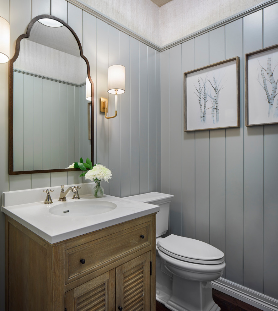 Small country powder room in Denver with furniture-like cabinets, medium wood cabinets, a one-piece toilet, green walls, dark hardwood floors, an integrated sink, solid surface benchtops, brown floor and white benchtops.