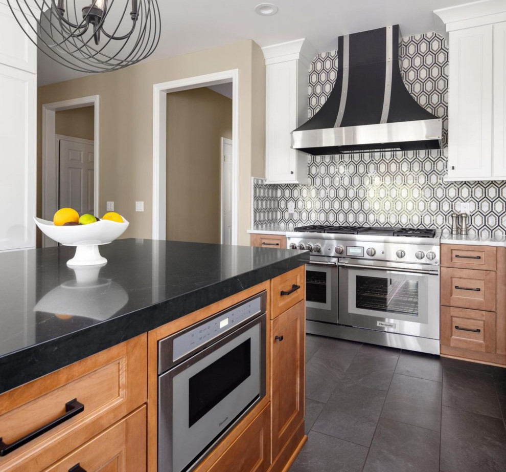 Foto på ett stort lantligt vit kök, med en nedsänkt diskho, släta luckor, vita skåp, bänkskiva i kvarts, flerfärgad stänkskydd, stänkskydd i keramik, rostfria vitvaror, en köksö och svart golv