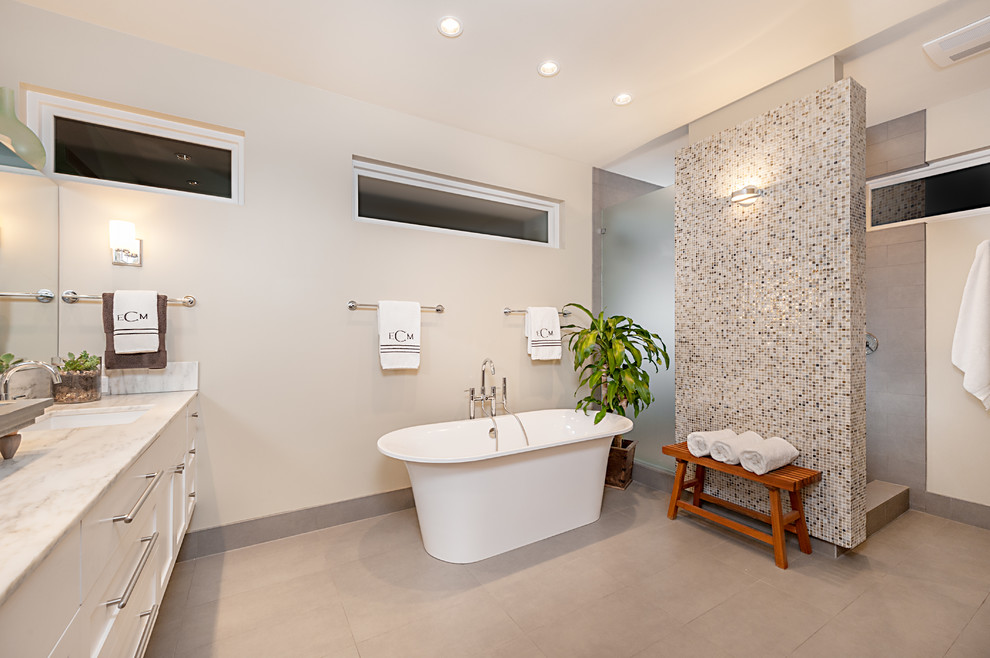 Immagine di una stanza da bagno tradizionale di medie dimensioni con doccia aperta, piastrelle grigie, piastrelle in gres porcellanato, pareti beige, pavimento con piastrelle di ciottoli, lavabo sottopiano e doccia aperta