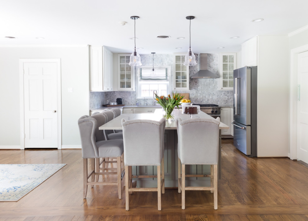Mid-sized transitional u-shaped dark wood floor and brown floor open concept kitchen photo with an undermount sink, raised-panel cabinets, white cabinets, solid surface countertops, gray backsplash, glass tile backsplash, stainless steel appliances, an island and white countertops