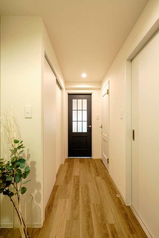 Immagine di un ingresso o corridoio scandinavo con pareti bianche, pavimento in compensato, soffitto in carta da parati e carta da parati