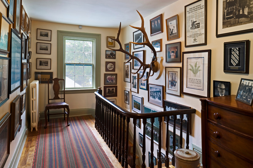 Photo of a traditional hallway in Other with beige walls and medium hardwood floors.