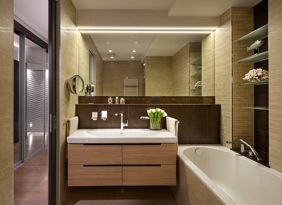 Mid-sized contemporary master bathroom in Moscow with flat-panel cabinets, light wood cabinets, beige tile, brown tile, an integrated sink, an alcove shower, a one-piece toilet, porcelain tile, beige walls, porcelain floors, solid surface benchtops and an alcove tub.
