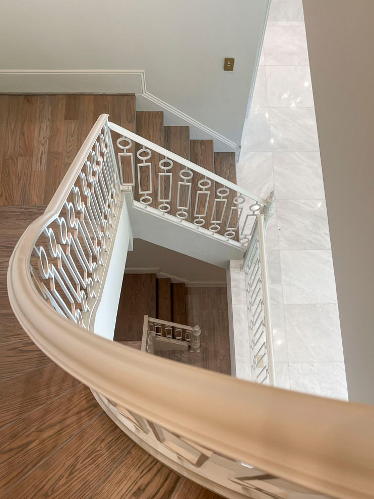 This is an example of an expansive transitional wood floating staircase in DC Metro with wood risers, metal railing and panelled walls.