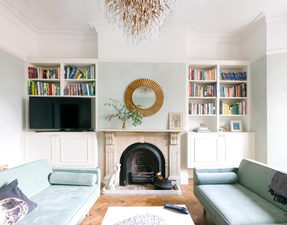 ロンドンにある高級な広いトラディショナルスタイルのおしゃれなリビング (緑の壁、標準型暖炉、石材の暖炉まわり、埋込式メディアウォール、茶色い床) の写真