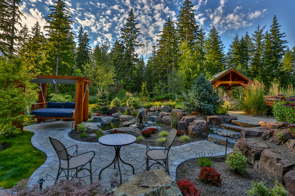 Inspiration for a large arts and crafts backyard patio in Seattle with a water feature, natural stone pavers and a gazebo/cabana.