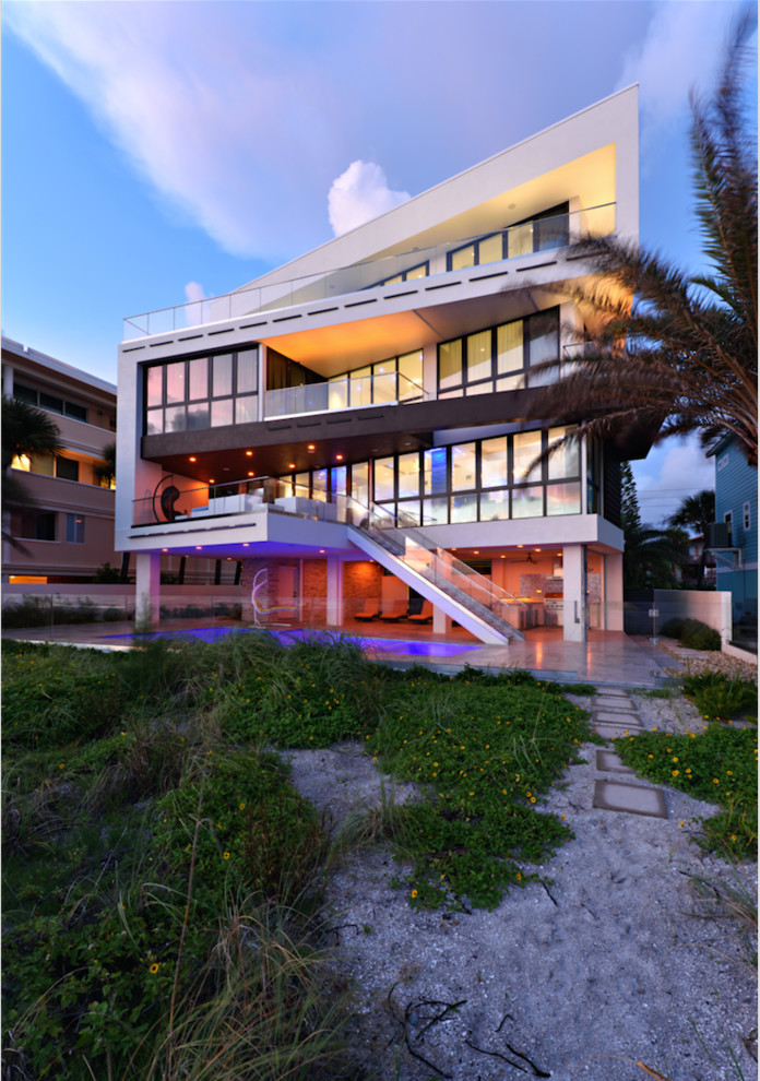 Photo of an expansive contemporary three-storey stucco white exterior in Tampa with a shed roof.