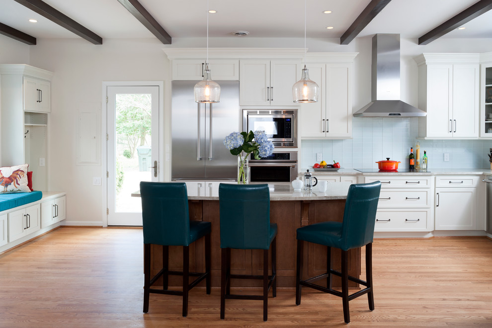 Large modern galley eat-in kitchen in DC Metro with shaker cabinets, white cabinets, granite benchtops, glass tile splashback, stainless steel appliances, with island, brown floor, a farmhouse sink, blue splashback and medium hardwood floors.