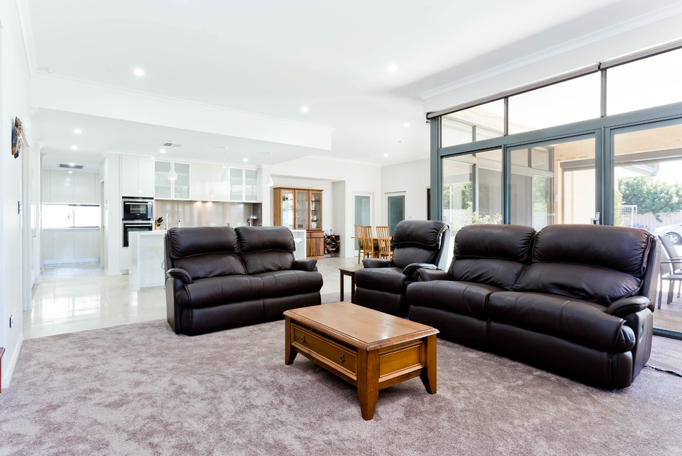 Photo of a large contemporary open concept family room in Perth with carpet, a standard fireplace, a metal fireplace surround, a wall-mounted tv, white walls and grey floor.