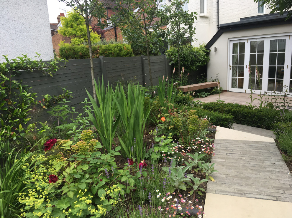 This is an example of a small contemporary backyard garden in London with brick pavers.