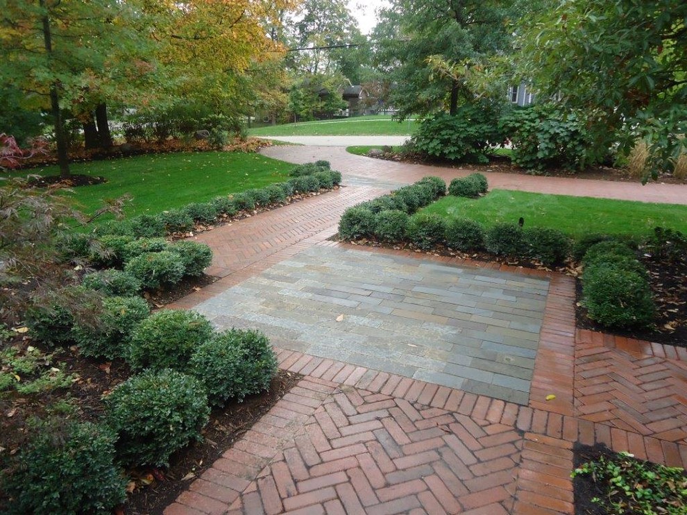 This is an example of a large contemporary front yard patio in Chicago with brick pavers and a pergola.