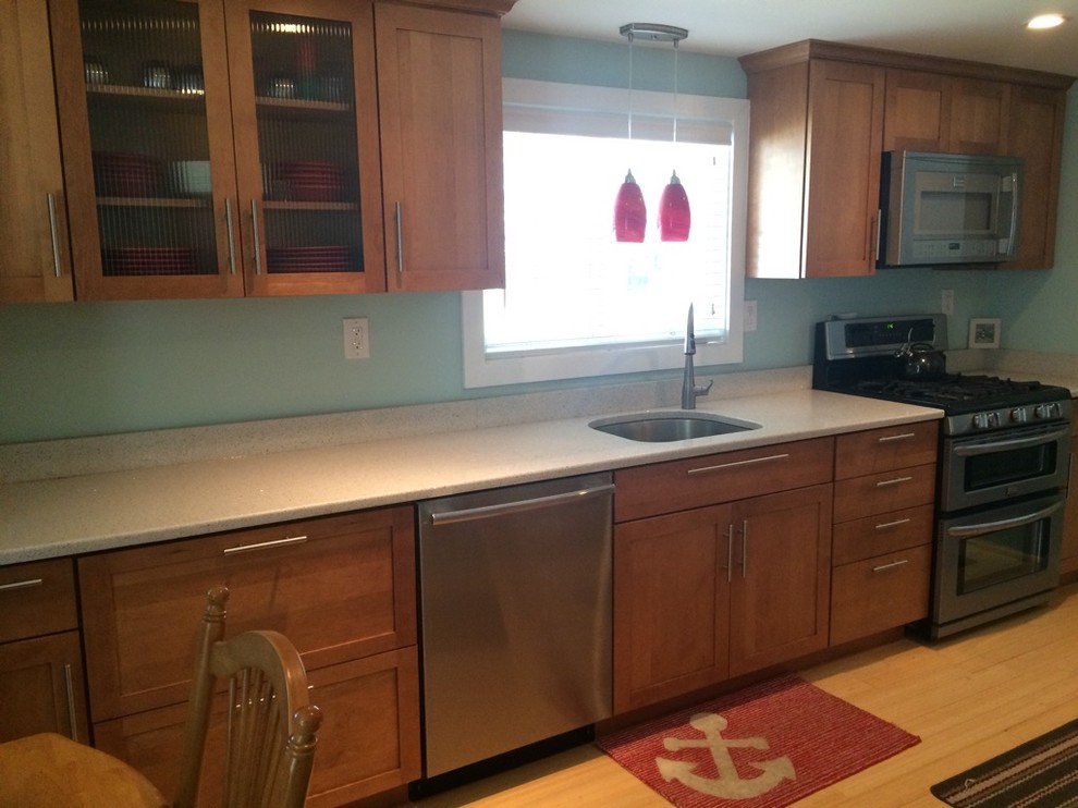 Eat-in kitchen - transitional galley light wood floor eat-in kitchen idea in Boston with an undermount sink, shaker cabinets, medium tone wood cabinets, quartz countertops, stainless steel appliances, no island and white countertops