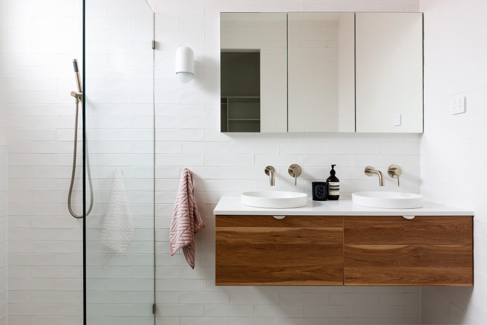 This is an example of a contemporary bathroom in Sydney with black cabinets, white tile, grey benchtops and a floating vanity.