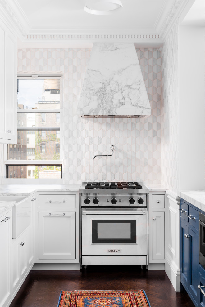 Example of a mid-sized transitional galley medium tone wood floor, brown floor and tray ceiling eat-in kitchen design in New York with a farmhouse sink, shaker cabinets, white cabinets, marble countertops, white backsplash, marble backsplash, paneled appliances, an island and white countertops