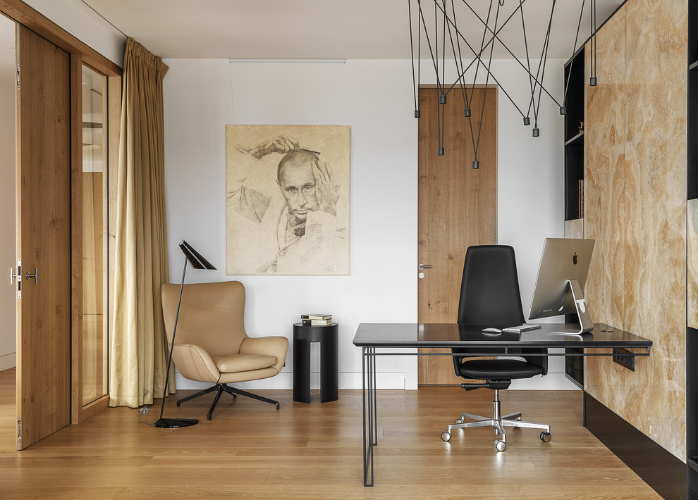 Photo of a contemporary study room in Moscow with white walls, medium hardwood floors, beige floor and a built-in desk.
