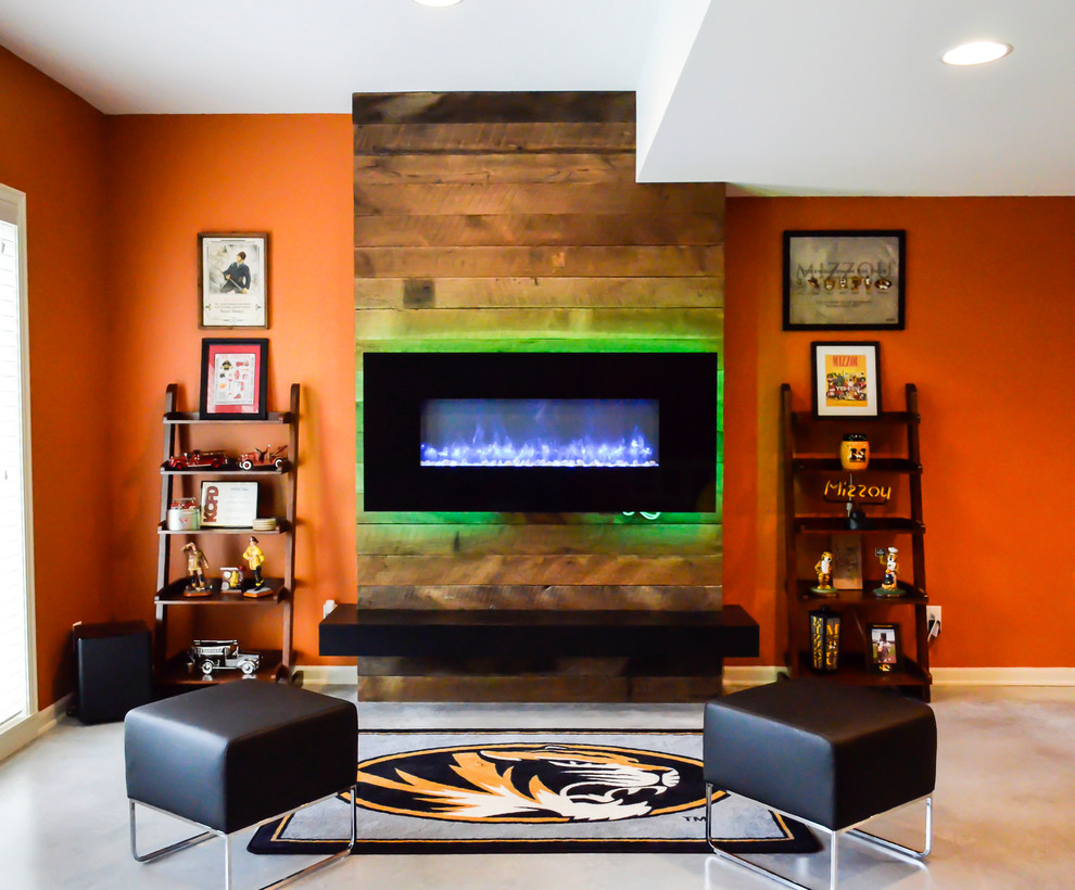 This is an example of a mid-sized modern walk-out basement in Kansas City with orange walls, concrete floors and a ribbon fireplace.