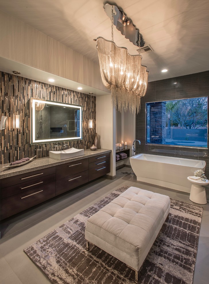This is an example of an expansive contemporary master bathroom in Phoenix with flat-panel cabinets, medium wood cabinets, a freestanding tub, gray tile, porcelain tile, grey walls, porcelain floors, a vessel sink, engineered quartz benchtops, grey floor and an open shower.