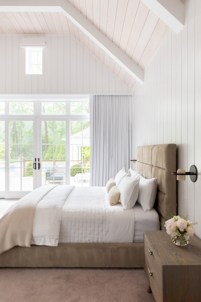 Cette image montre une grande chambre traditionnelle avec un mur blanc, une cheminée, un manteau de cheminée en lambris de bois, un sol beige, un plafond voûté et du lambris.