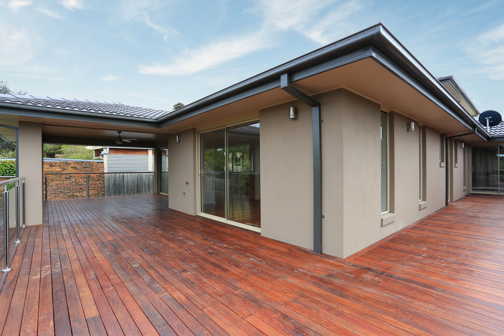 This is an example of a mid-sized modern balcony in Melbourne with a roof extension.