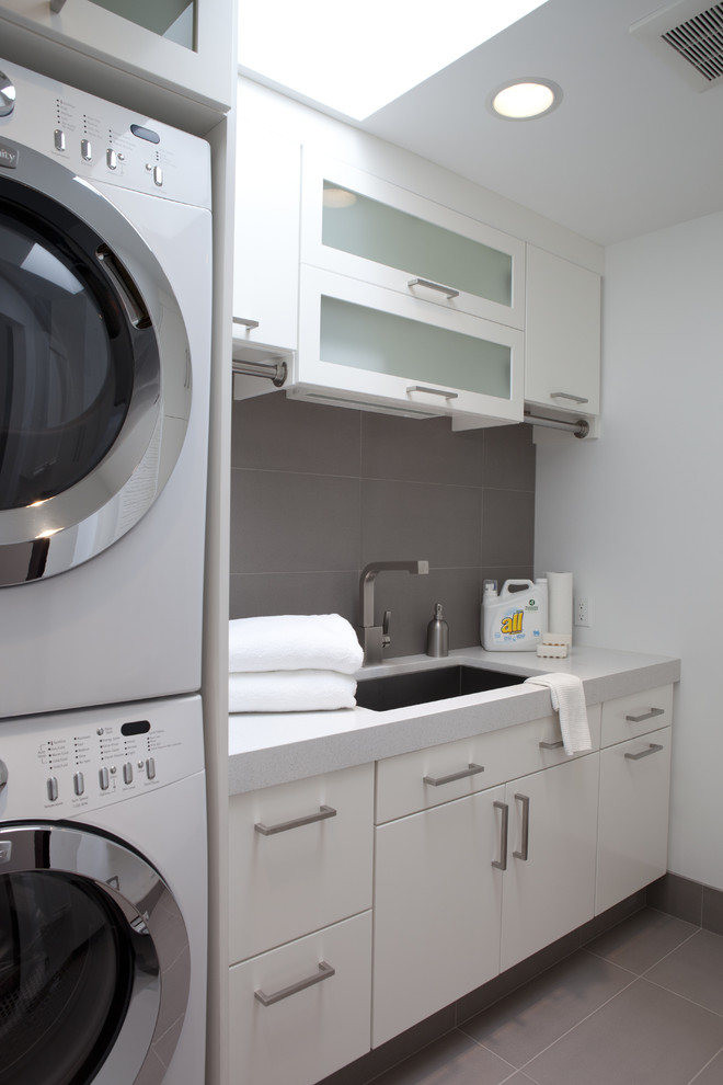 Contemporary laundry room in Other with a stacked washer and dryer.